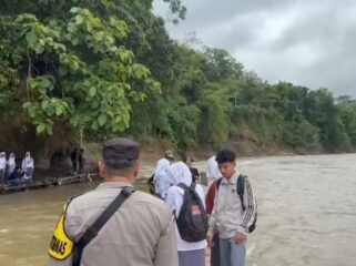 Sejumlah Pelajar harus menyeberangi Sungai Cibuni menggunakan rakit lantaran terputusnya akses Jembatan sejak tahun 2021. (Foto : cianjur Times/Mohammad Andri)