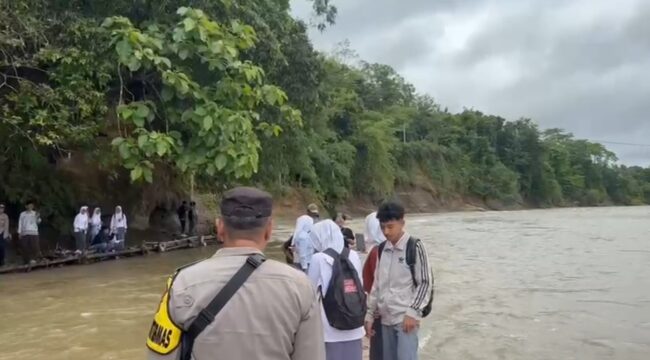 Sejumlah Pelajar harus menyeberangi Sungai Cibuni menggunakan rakit lantaran terputusnya akses Jembatan sejak tahun 2021. (Foto : cianjur Times/Mohammad Andri)