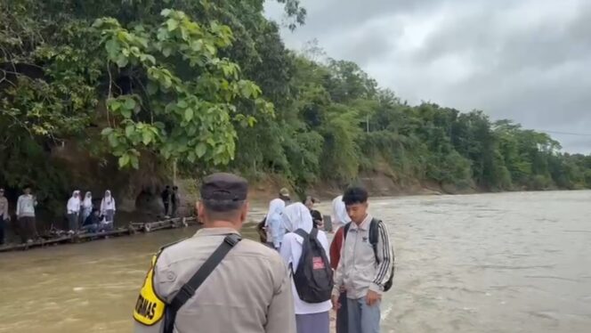 
					Sejumlah Pelajar harus menyeberangi Sungai Cibuni menggunakan rakit lantaran terputusnya akses Jembatan sejak tahun 2021. (Foto : cianjur Times/Mohammad Andri)