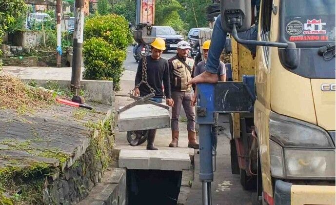 PetugasKementerian PUPR saat menutup drainaseyang terbuka di jalu Puncak-Cipanas, Jumat (3/4/2026)
